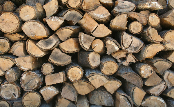 Photographie illustrative de bois de chauffage empilé — Bois de chauffage Olivier — Sac 10 kg